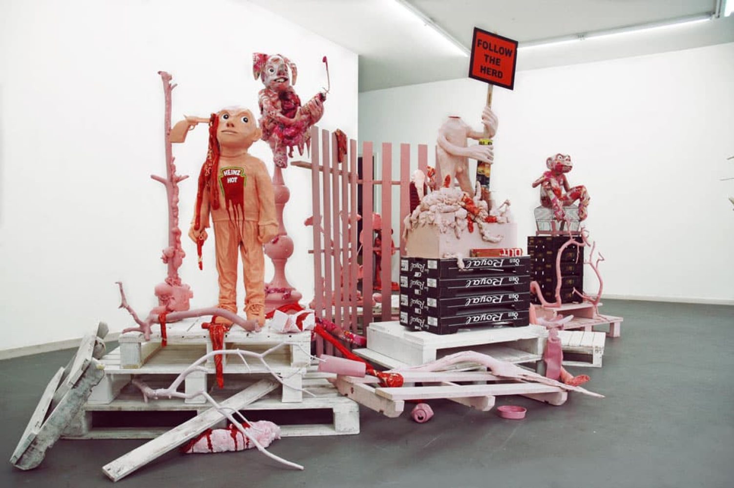 Installation view of Platonic Ideals & Hot Ketchup, with red and white sculptural figures and objects.