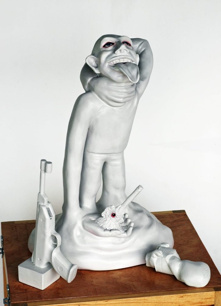 Detail of a sculptural hand holding a chicken head with a cigar in its beak.