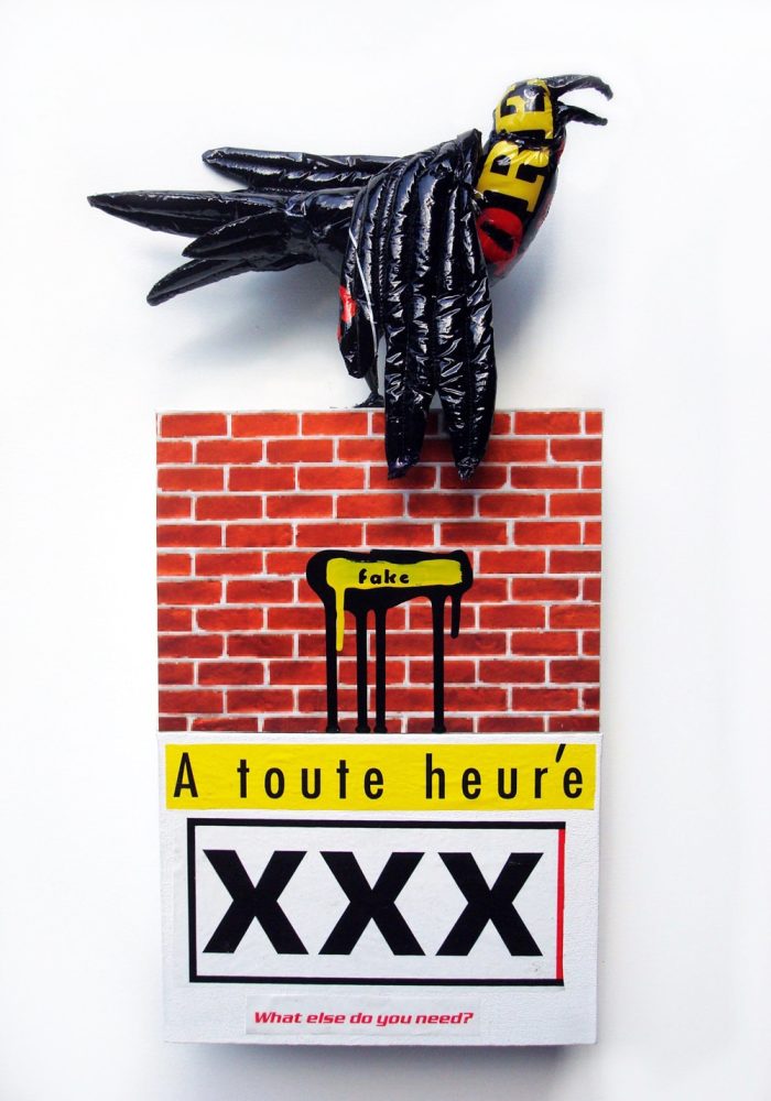 Black bird-like figure perched above a brick-patterned structure with text and the letters “XXX”.