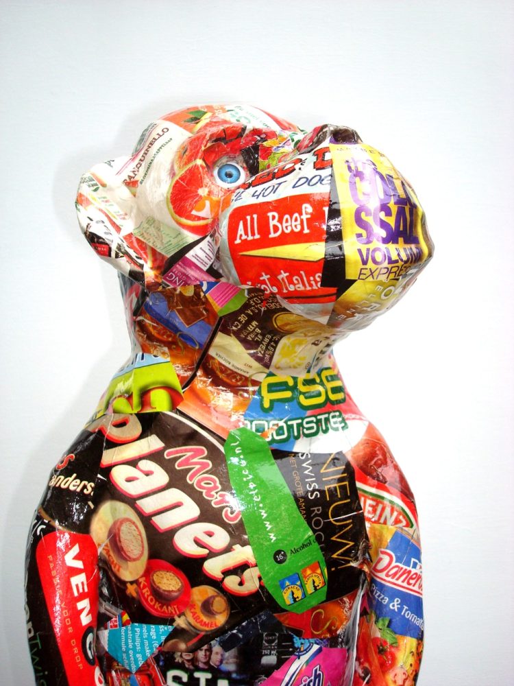 Detail of Impersonation, showing the head and upper body covered with fragments of advertising and printed material.
