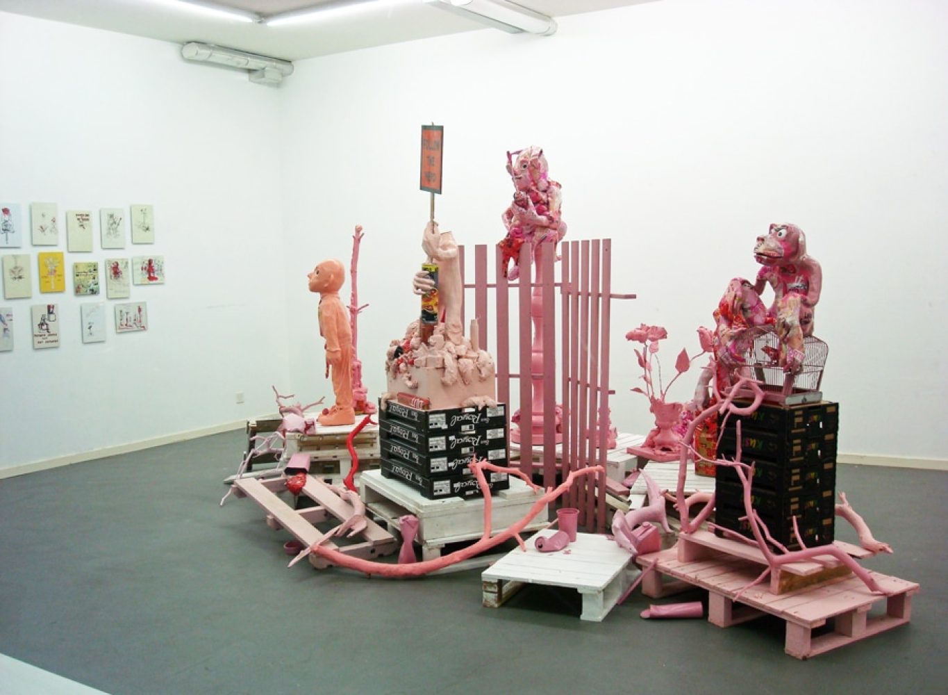 Installation view of Platonic Ideals & Hot Ketchup, with red and white sculptural figures and objects.