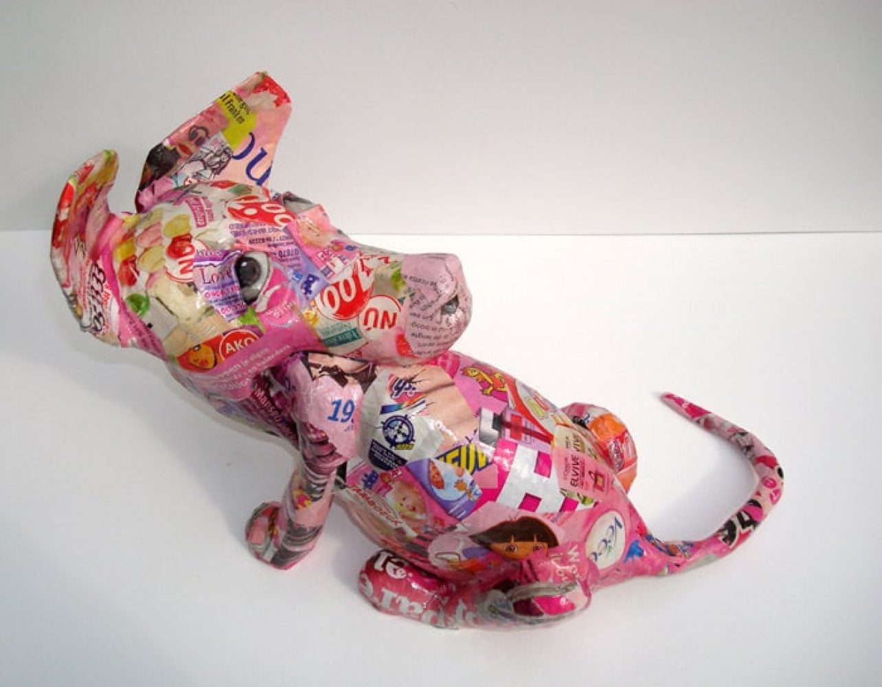 Dog-like sculptural head eating its own body.