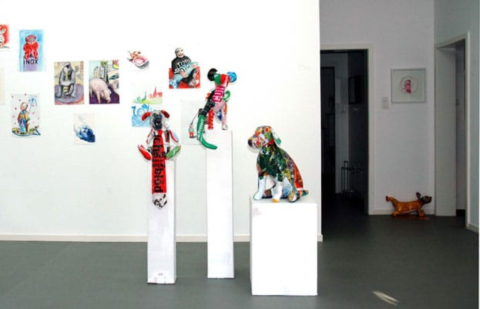 Exhibition view of Synthetic Ivory with three colourful sculptures made from plastic shopping bags displayed on plinths made from recycled cardboard.